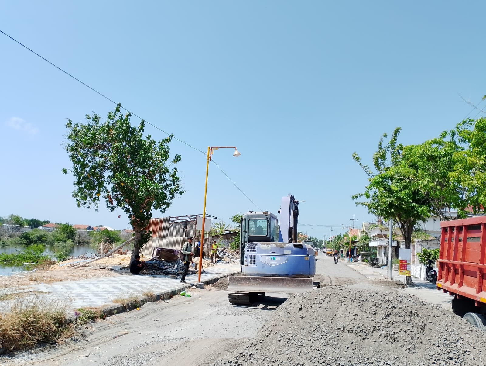 PROYEK: Warga melihat pengerjaan proyek jalan di Desa Branta Pesisir, Kecamatan Tlanakan, Pamekasan, Minggu (17/9). (MOH. JUNAIDI/JPRM)