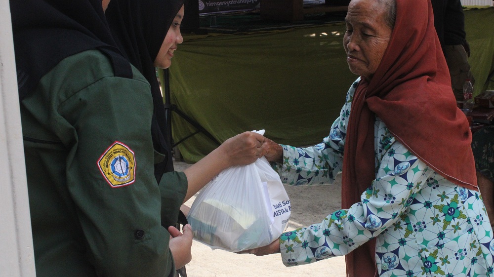 PEDULI: Panitia bakti sosial Hemaesya UTM memberikan sembako kepada warga Desa Pettong, Kecamatan Tanah Merah, Bangkalan, Sabtu (16/9). (HIMAESYA UTM UNTUK JPRM)