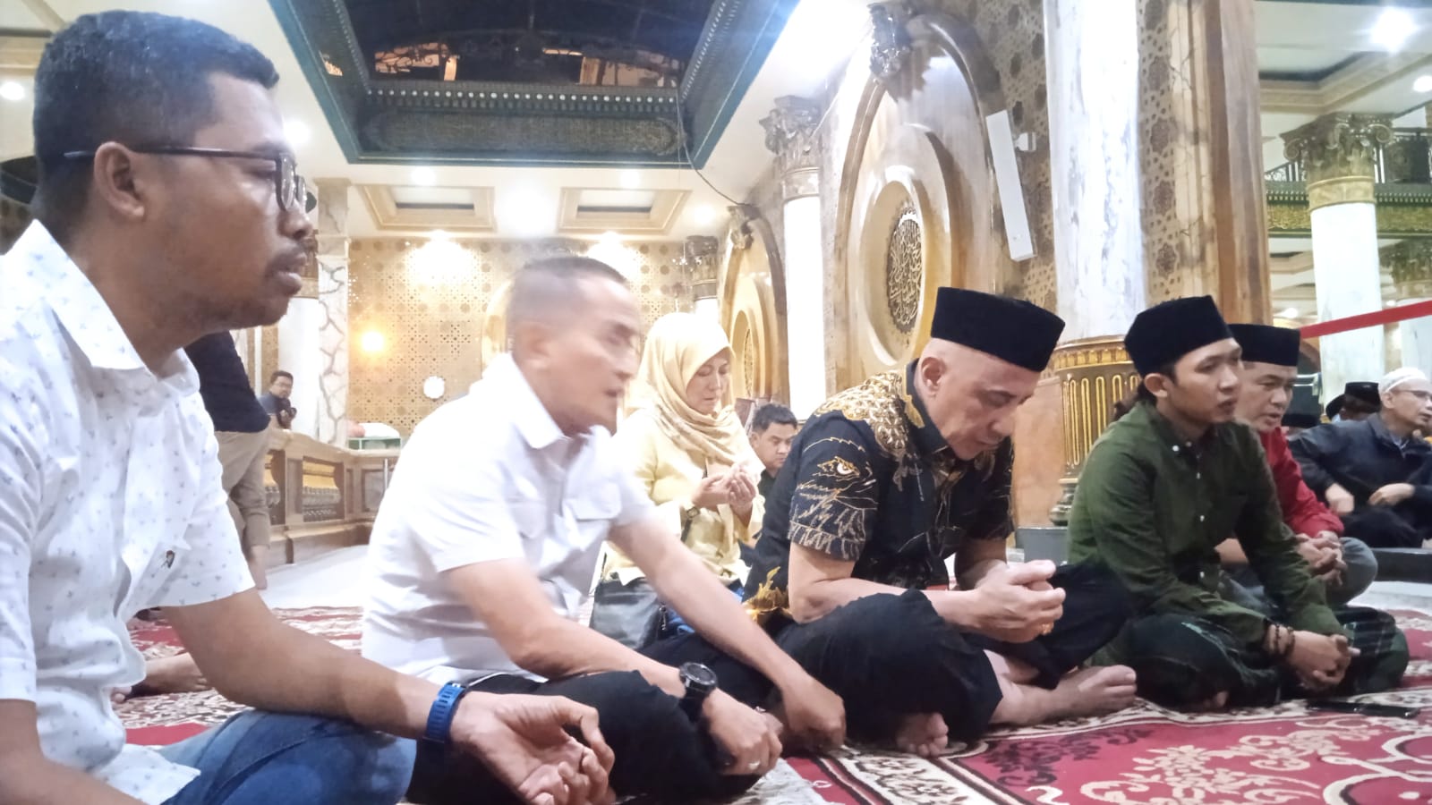 MEMANJATKAN DOA: Pj Bupati Bangkalan Arif Mulya Adi (kemeja batik) di samping Sekkab Taufan Zairinsjah (dua, kanan) berziarah di Pasarean Syaikhona Muhammad Kholil, Sabtu (23/9) malam. (JUPRI/JPRM)