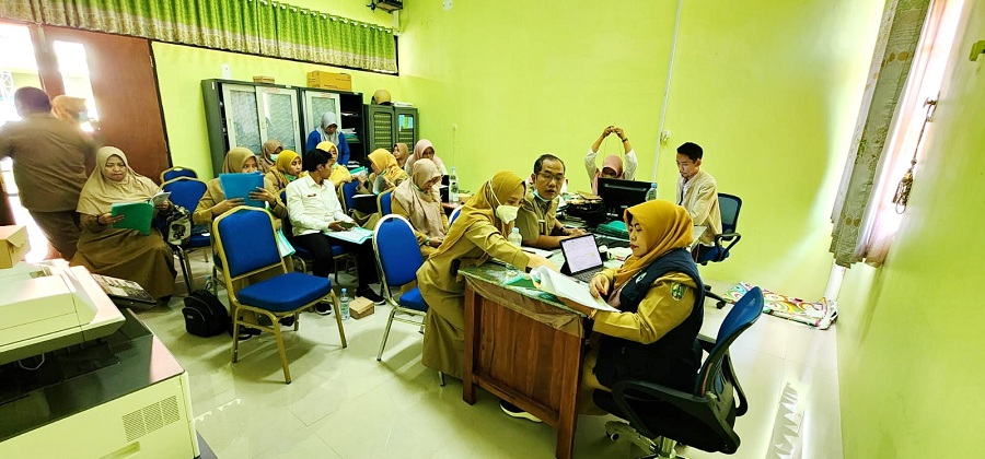 SERIUS: Kabid Yankes Dinkes dan KB Sampang Nurul Sarifah melihat kelengkapan dokumen jelang pelaksanaan reakreditasi Puskesmas Camplong, Senin (4/9). (DINKES KB SAMPANG UNTUK JPRM)