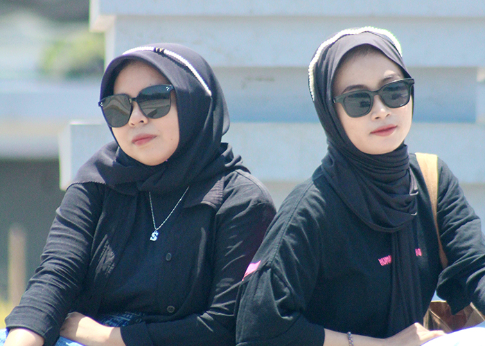 PADU: Siti Nurkholisah Khoyr (kiri) dan Selviana Febriyanti kompak menggunakan bando dan kacamata di Alun-Alun Trunojoyo. (MOH. IQBAL AFGANI/JPRM)
