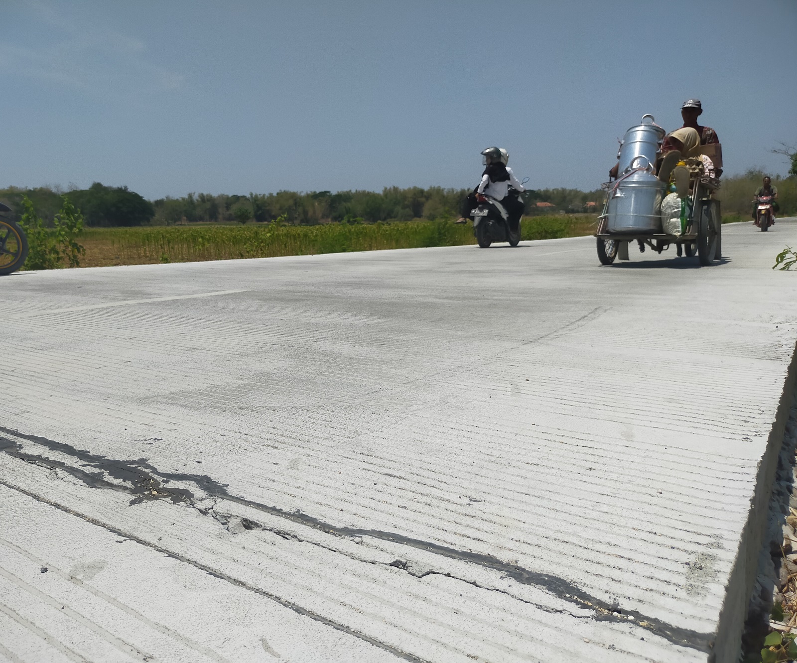 RETAK: Pengendara lalu-lalang melewati jalan beton Panggung&ndash;Pangilen, Sampang, yang mengalami retak hasil pekerjaan CV Putra Alam Perkasa Senin (25/9). (ANIS BILLAH/JPRM)