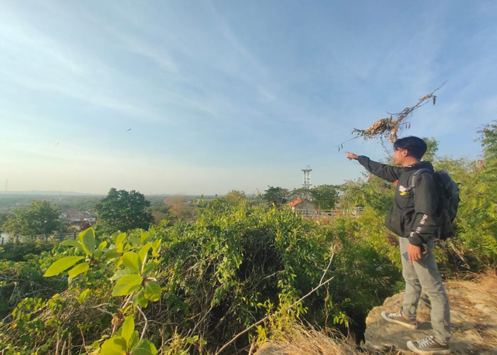 SANTAI: Warga bersantai sembari menikmati pemandangan di area atas Wisata Goa Lebar. (MOH. IQBAL AFGANI/JPRM)