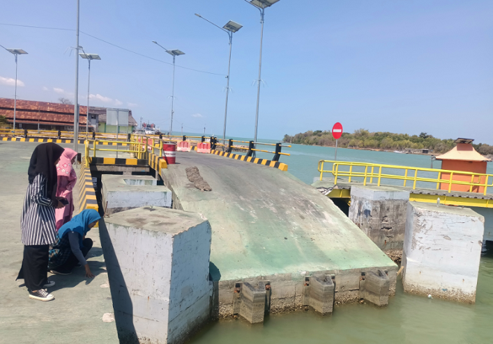 DISOROT: Remaja melihat kondisi dermaga Pelabuhan Kalainget yang dinilai curam Selasa (3/10). (MOH. IQBAL/JPRM)