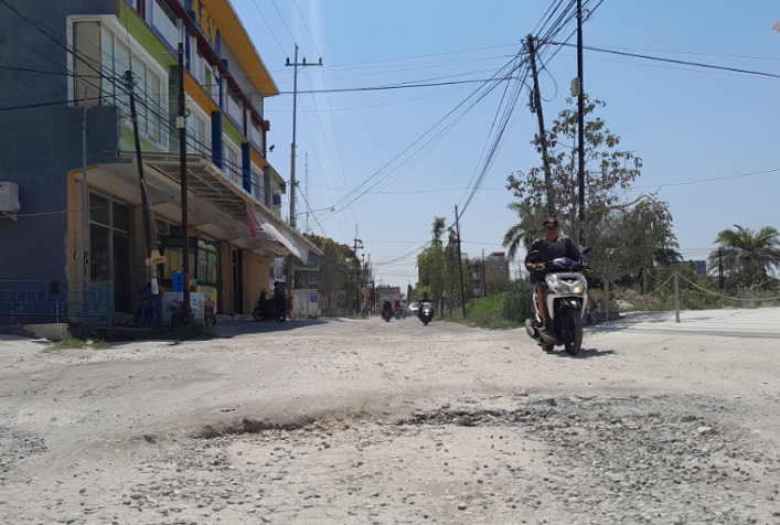 DAPAT ANGGARAN BESAR: Pengendara motor melintas di Jalan Adirasa, Sumenep, yang sudah mengalami kerusakan parah Jumat (6/10). (MOH. BUSRI/JPRM)