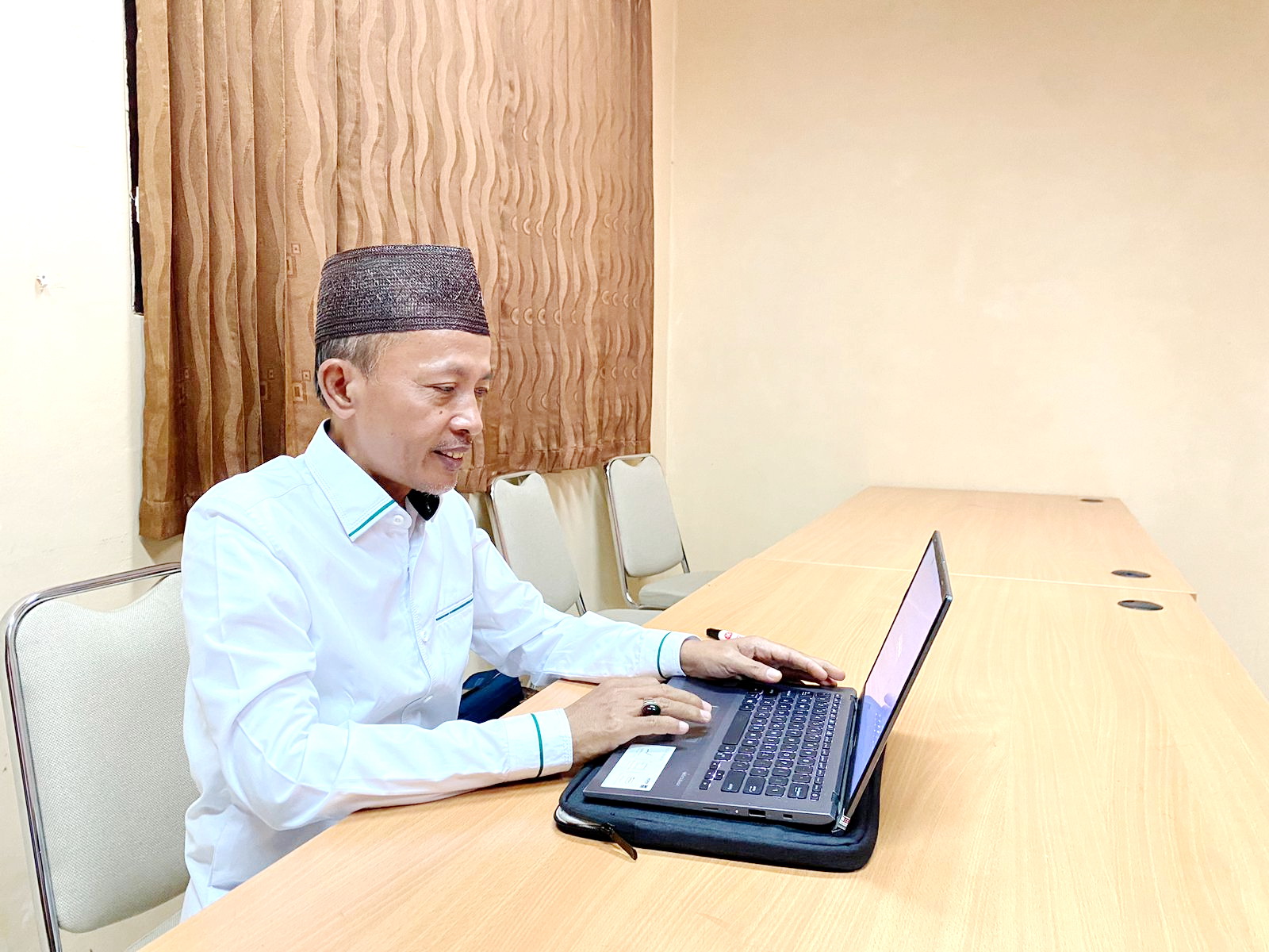 BERKARYA: Prof Kosim menyelesaikan karya tulis di sela-sela waktu senggang dari mengajar, Jumat (29/9). (MOH. JUNAIDI/JPRM)