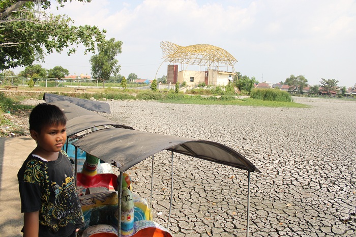 TIDAK TERAWAT: Seorang bocah berada di area Taman Rekreasi Kota Bangkalan yang mengering Senin (9/10). (VIVIN AGUSTIN HARTONO/JPRM)