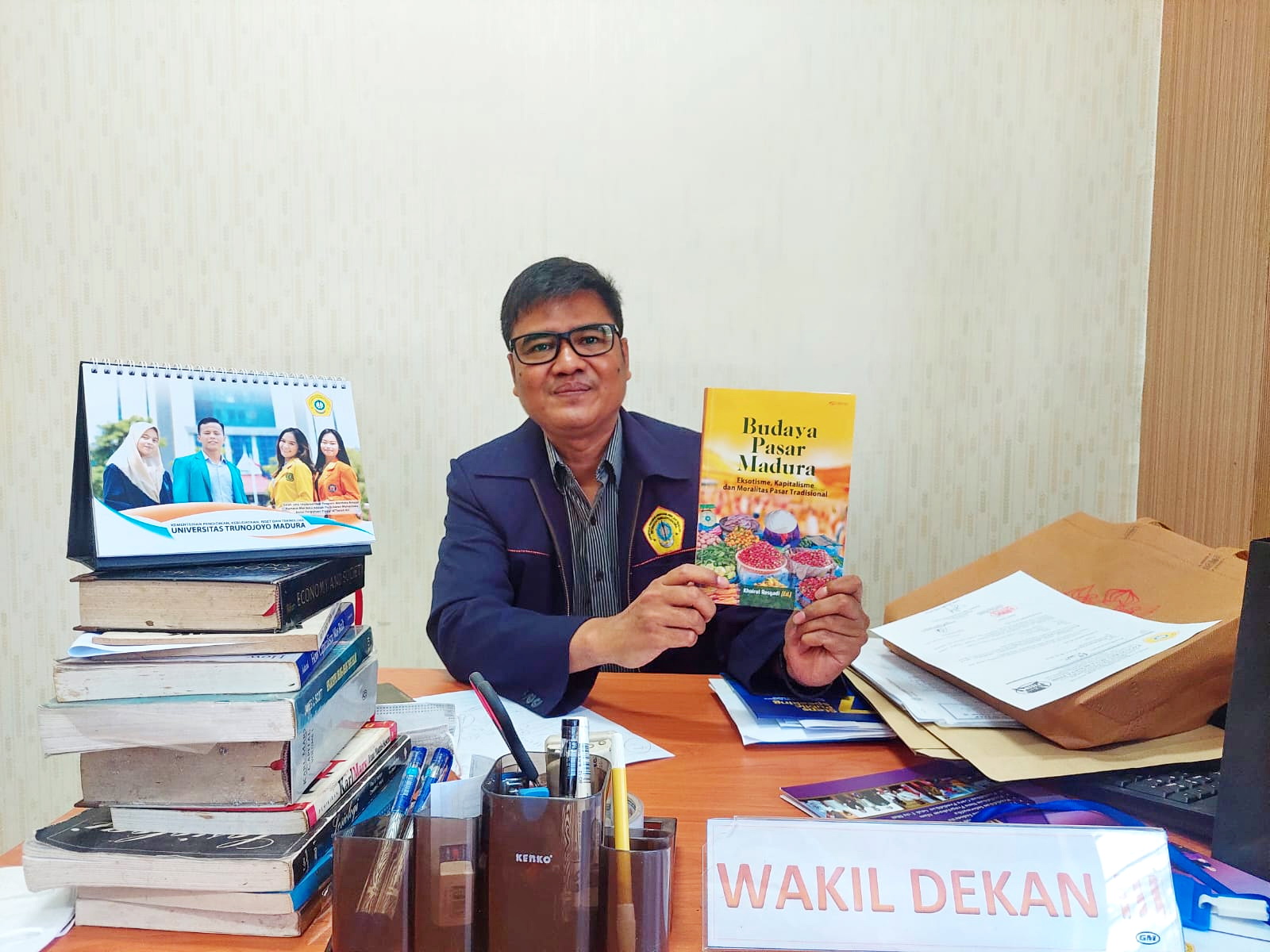 RAMAH: Profesor Khoirul Rosyadi menunjukkan buku tentang budaya Madura di ruang kerjanya, Senin (9/10). (ZEINAL ABIDIN/JPRM)