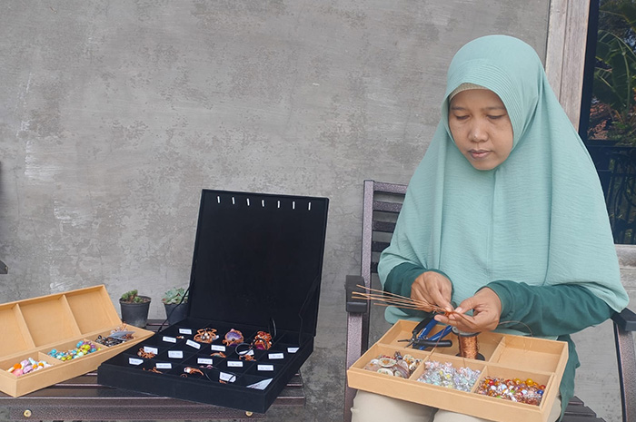 TELATEN: Saidah membuat aksesori pesanan pelanggan di Jalan Gatot Koco gang IV, Kelurahan Kolpajung, Kecamatan Kota Pamekasan. (UBAIDILLAHIR RA&rsquo;IE/JPRM)