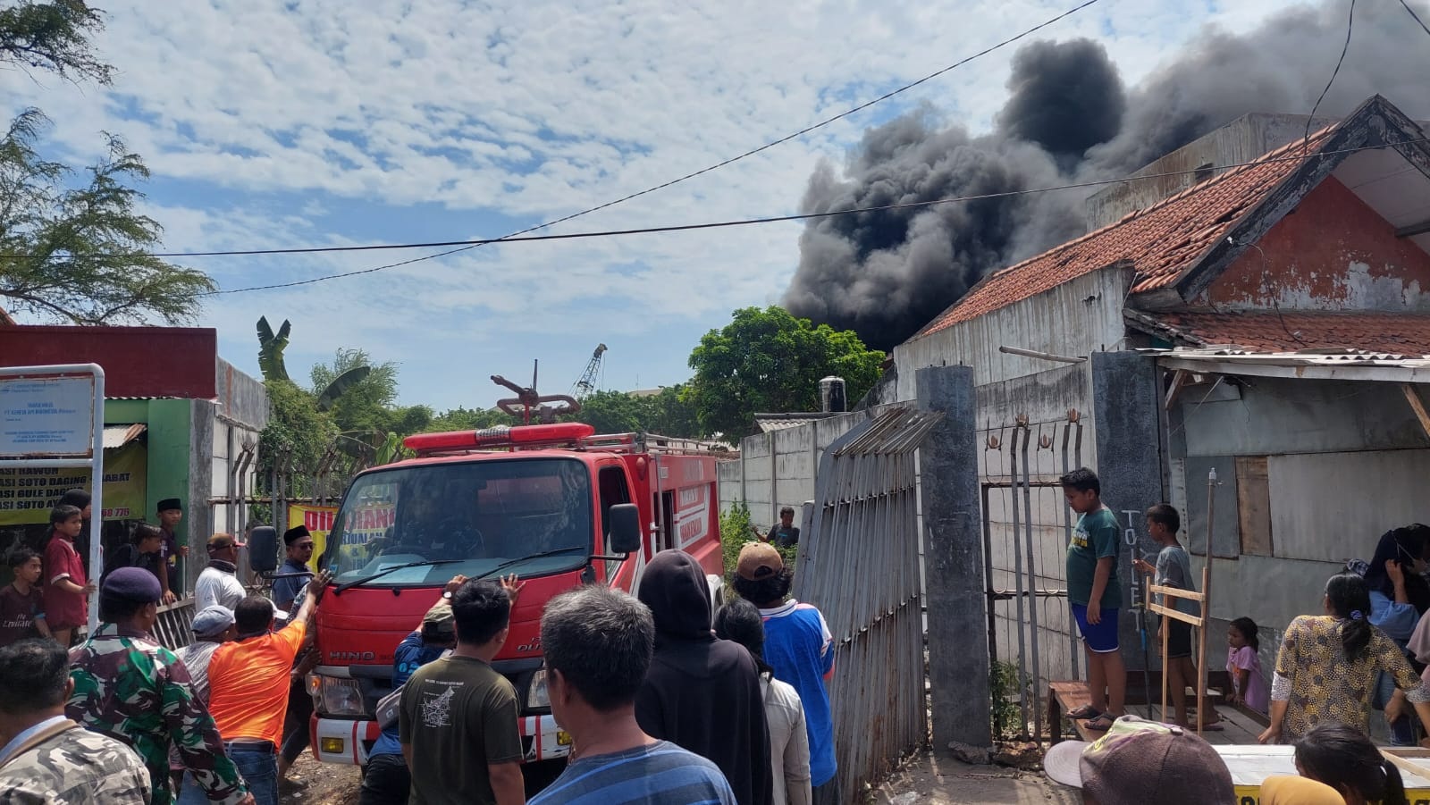 KESULITAN EVAKUASI: Petugas pemadam kebakaran dan warga memadamkan api di area PT Ben Santosa, Kamal, Kamis (19/10). (ZEINAL ABIDIN/JPRM)