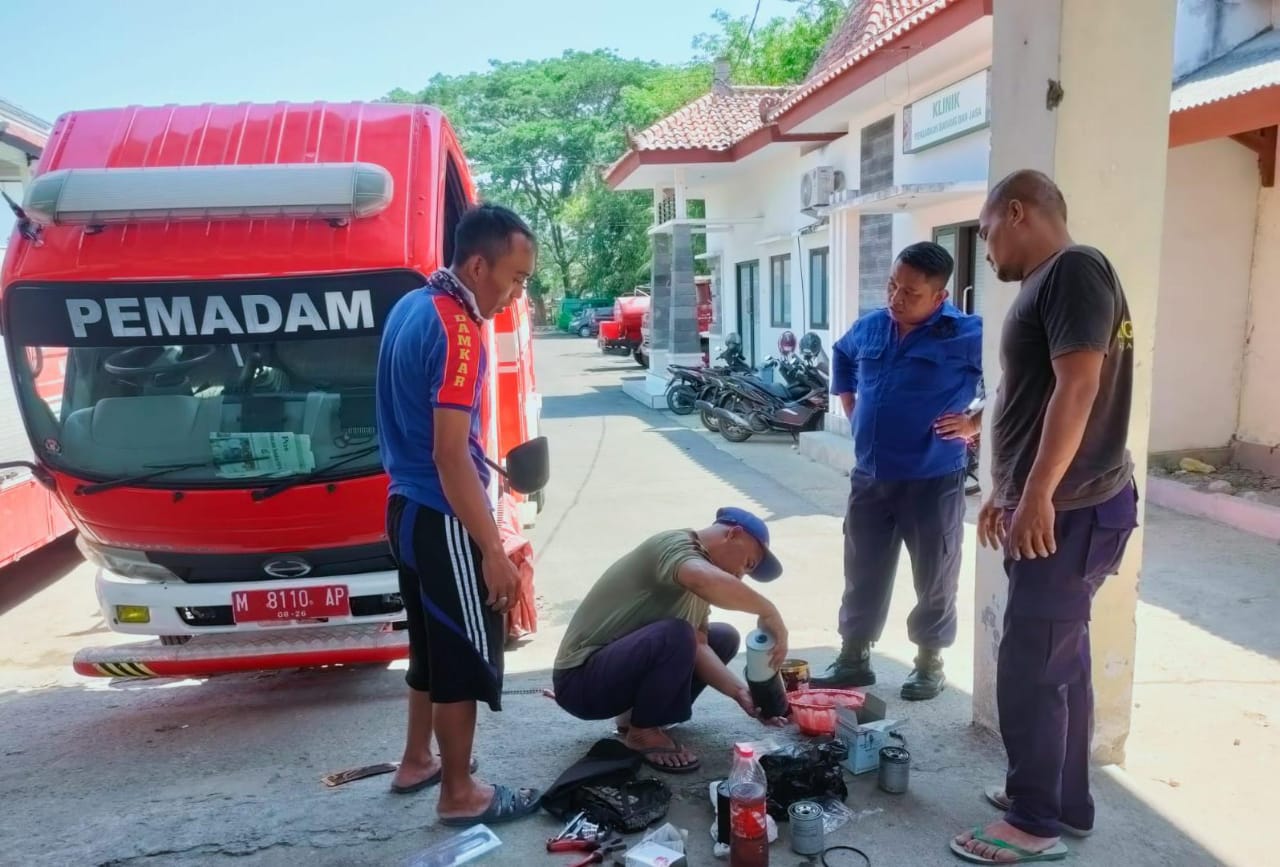 LAWAS: Petugas damkar memperbaiki armada pemadam kebakaran di kantor Satpol PP dan Damkar Pamekasan Kamis (19/10). (FAHMI JALIL/JPRM)