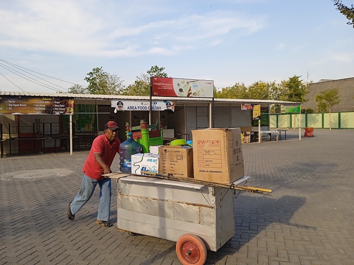 USAHA: Seorang pedagang di sentra PKL Food Colony mendorong gerobak jualan Minggu (22/10). (FAHMI JALIL/JPRM)