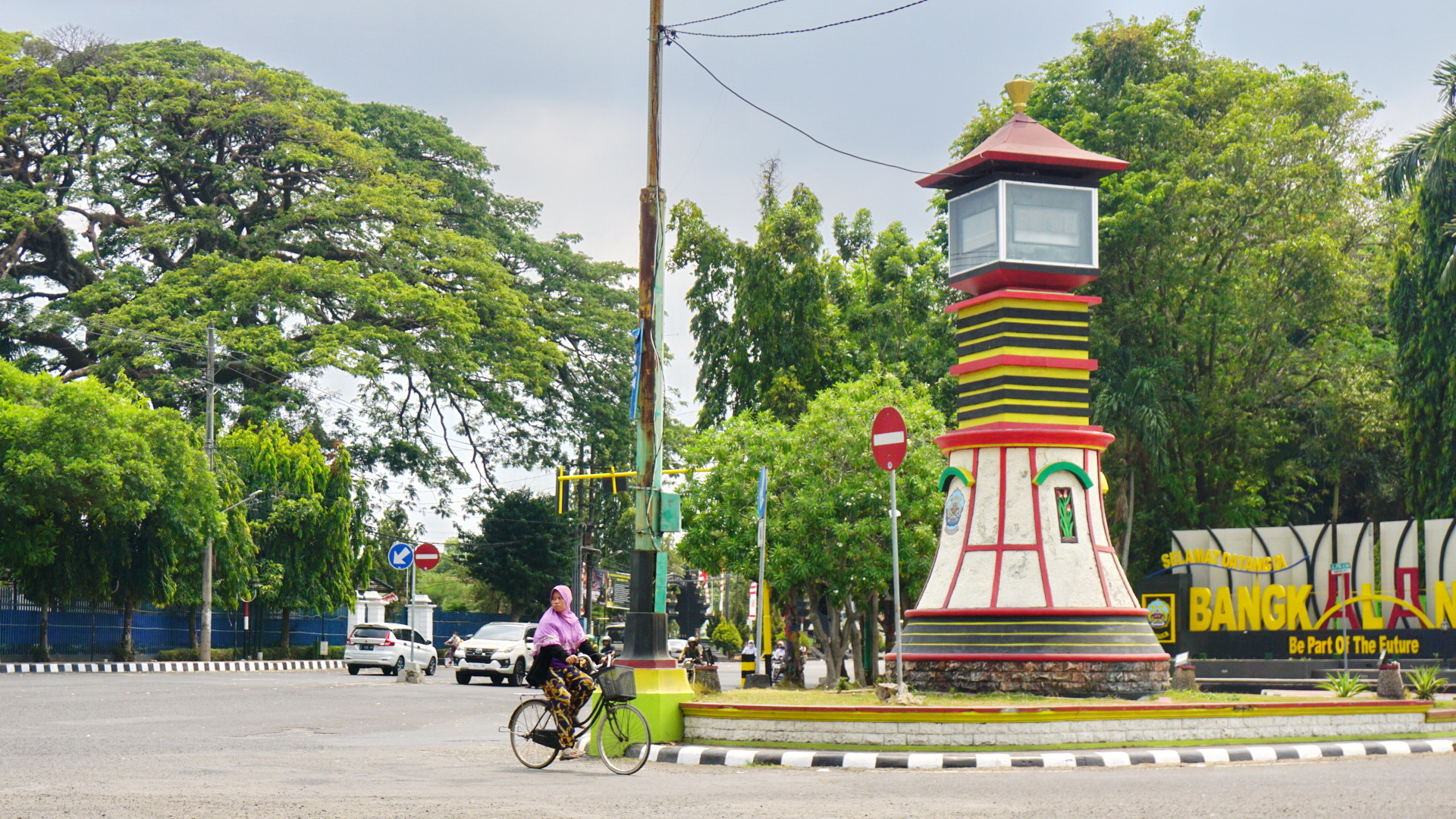IKON:&nbsp; Warga bersepeda di dekat tugu Kabupaten Bangkalan di Jalan Jenderal A. Yani kemarin. (VIVIN AGUSTIN HARTONO/JPRM)