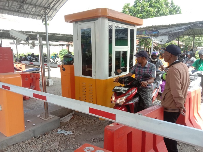 TERTIB: Warga mengantre saat hendak keluar dari Pasar 17 Agustus yang terletak di Kelurahan Bugih, Kecamatan Kota Pamekasan, Kamis (13/7). (LAILIYATUN NURIYAH/JPRM)