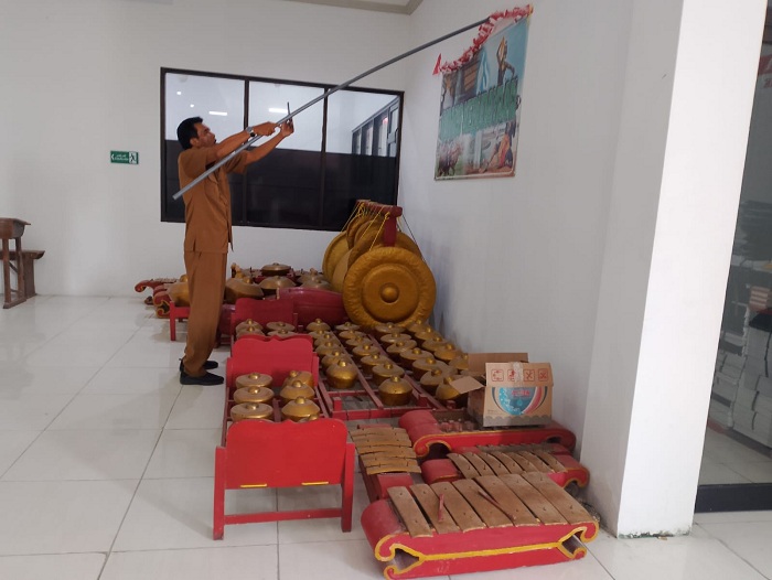 RUTIN: Staf Dispendikbud Pamekasan membersihkan ruangan yang menjadi tempat penyimpanan alat musik tradisional Senin (23/10). (UBAIDILLAHIR RA&rsquo;IE/JPRM)