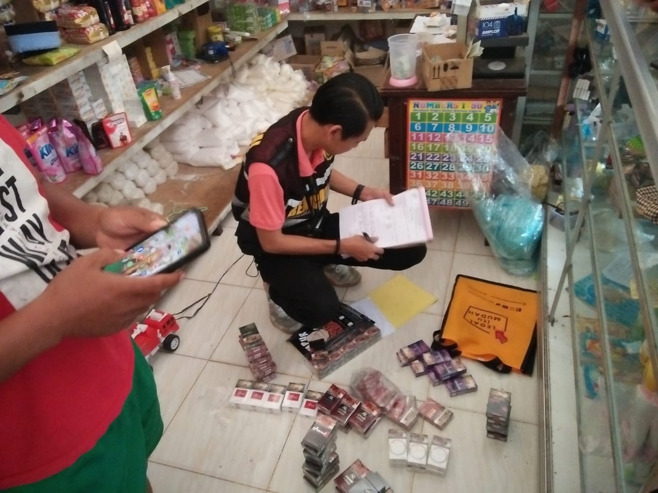 KOMITMEN: Tim gabungan melakukan operasi untuk menekan peredaran rokok ilegal di salah satu toko di Kecamatan Bluto, Sumenep, Selasa (24/10). (SATPOL PP SUMENEP UNTUK JPRM)