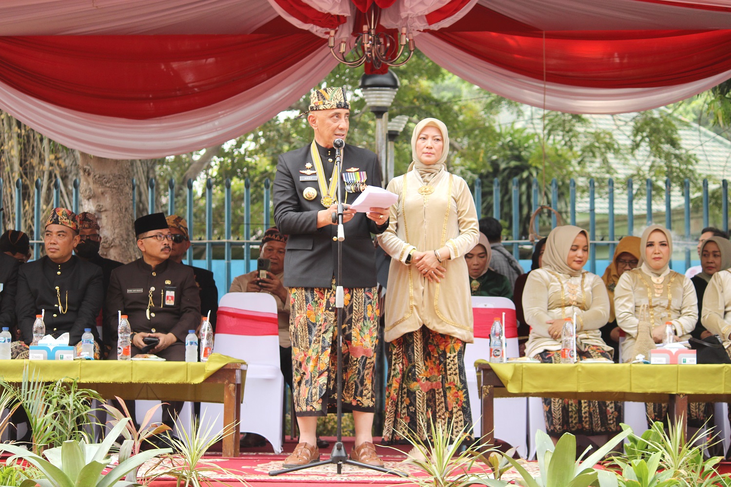 MELESTARIKAN: Pj Bupati Bangkalan Arief M. Edie didampingi istrinya, Siti Nur Huda Arief, menyampaikan sambutan dalam pembukaan kirab budaya di depan Pendopo Agung, Selasa (24/10). (VIVIN AH/JPRM)