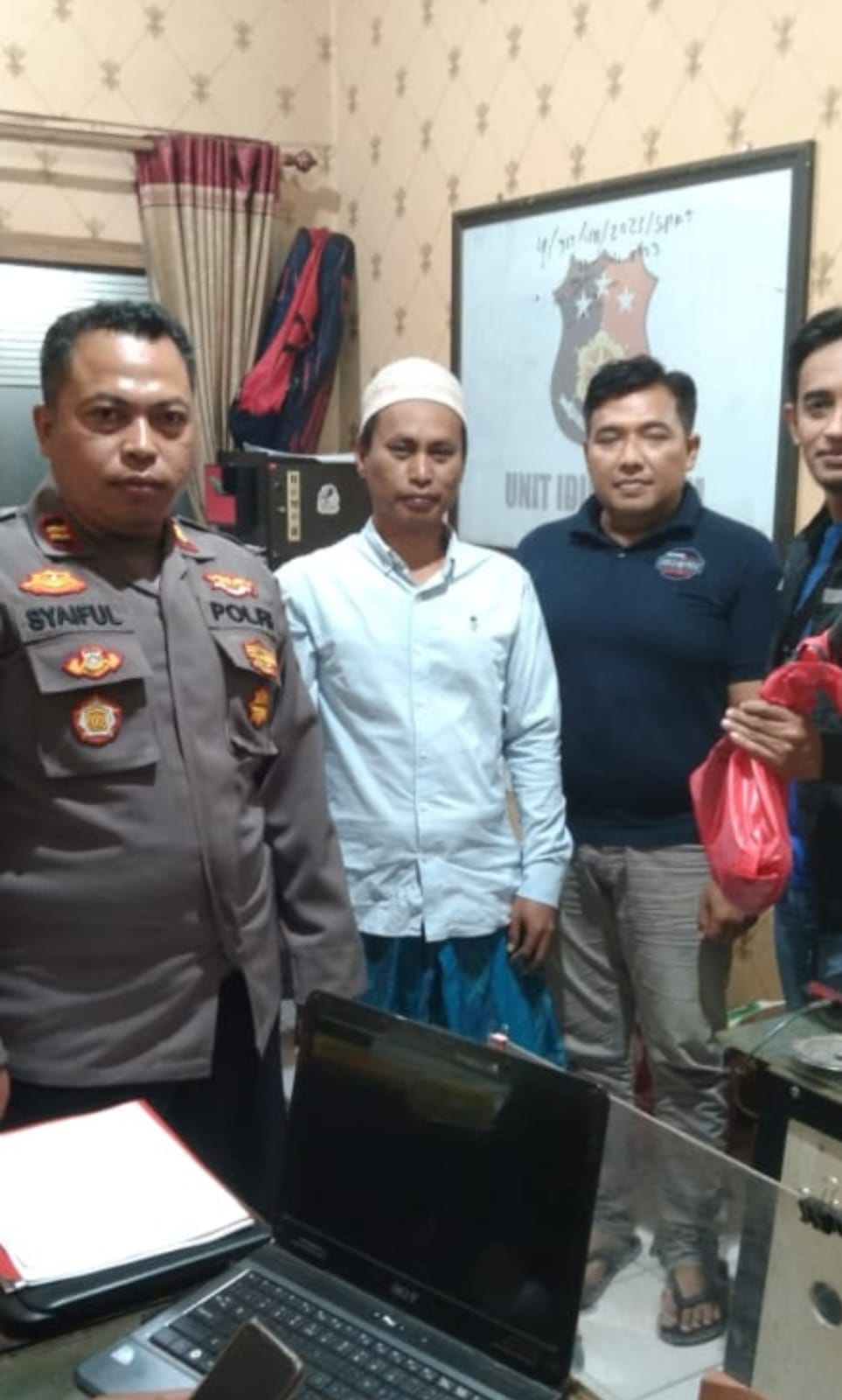 DIAMANKAN: Tersangka Romli (peci putih) saat diamankan oleh personel kepolisian di Polsek Tamberu, Pamekasan, Selasa (24/10). (POLSEK TAMBERU UNTUK JPRM)