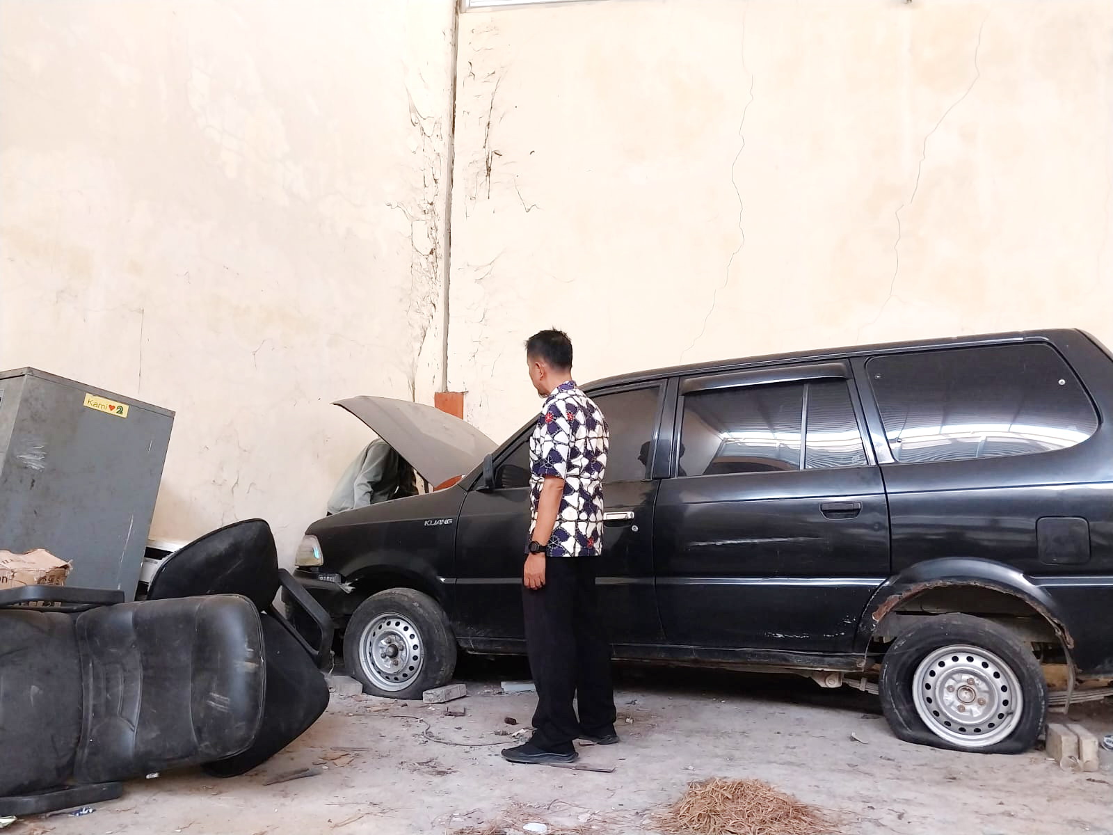 TIDAK TERPAKAI: Kabid Pengelolaan Aset Daerah BPPKAD Sampang Achmad Murang melihat kondisi kendaraan roda empat di gudang penyimpanan, Kamis (26/10). (BPPKAD SAMPANG UNTUK JPRM)