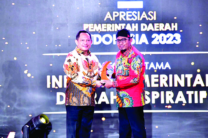 SUKSES: Bupati Sumenep Achmad Fauzi Wongsojudo (kanan) menerima penghargaan dari Divisi B Universe di ajang Apresiasi Pemerintah Daerah Indonesia (APDI).