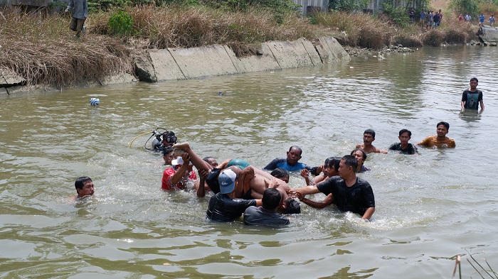 DITEMUKAN: Petugas BPBD dan warga mengevakuasi korban di Kali Kamoning, tepatnya di Kelurahan Rongtengah, Kecamatan Kota Sampang, Rabu (1/11). (MOH. IQBAL AFGANI/JPRM)