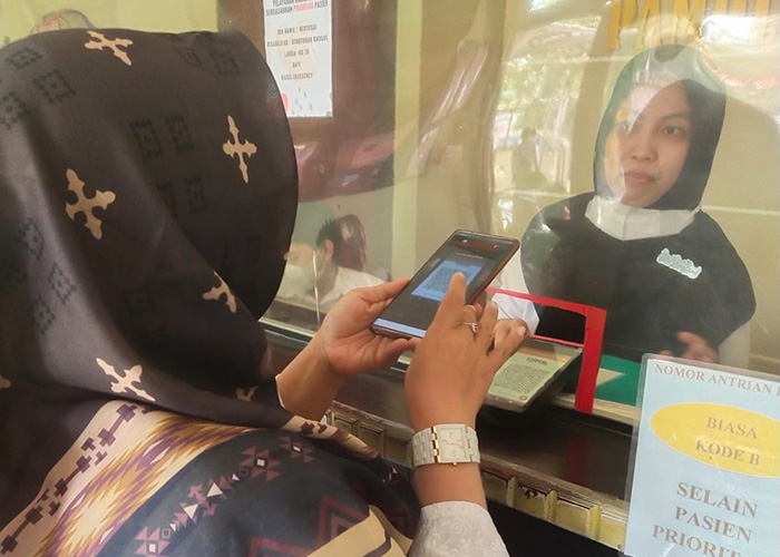 LEBIH MUDAH: Pengunjung Puskesmas Pamolokan melakukan pembayaran layanan kesehatan secara nontunai. (DINKES P2KB UNTUK JPRM)