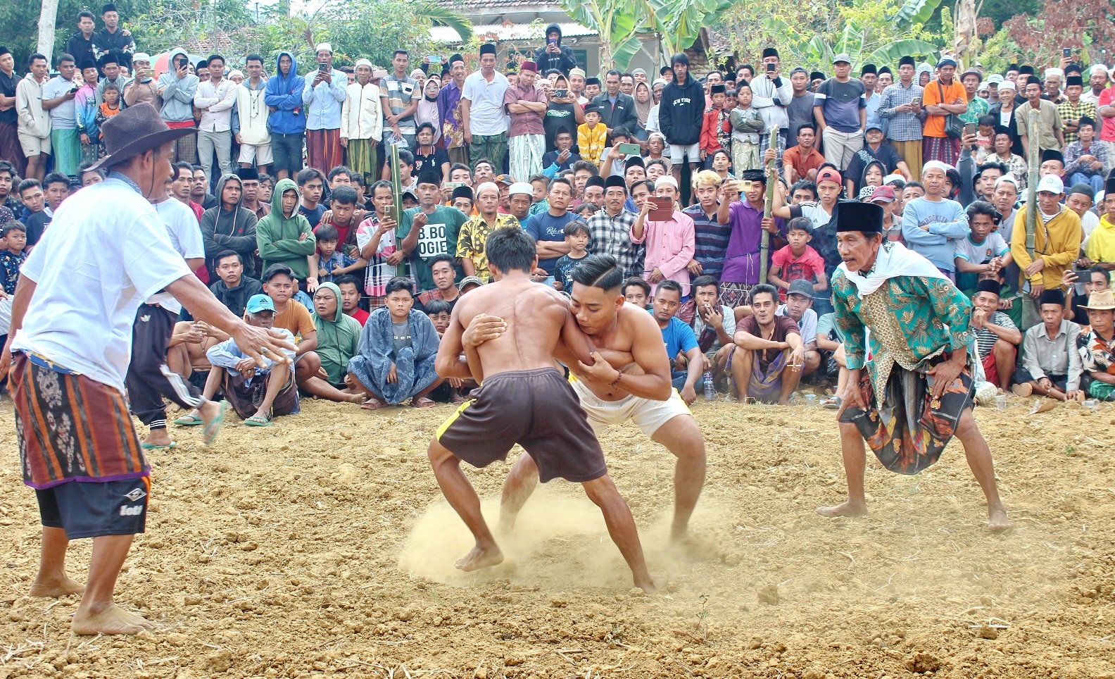 PENUH SEMANGAT: Peserta berusaha saling menjatuhkan di tengah arena okol di Dusun Bunut, Desa Plakpak, Kecamatan Pegantenan, Pamekasan, Jumat (3/11). (FAHMI JALIL/JPRM)