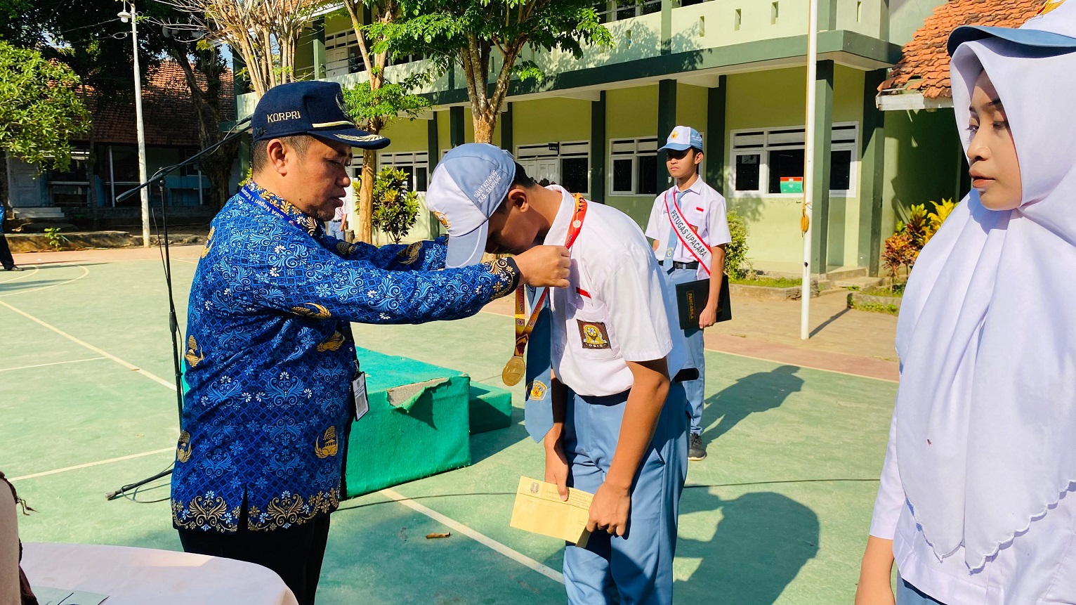 MENGAYOMI: Kepala SMA Negeri 1 Ketapang Sulaiman (pakai batik) menyerahkan penghargaan kepada siswa berprestasi usai upacara Hari Kesaktian Pancasila Minggu (1/10). (SMPN 1 KETAPANG FOR JPRM)