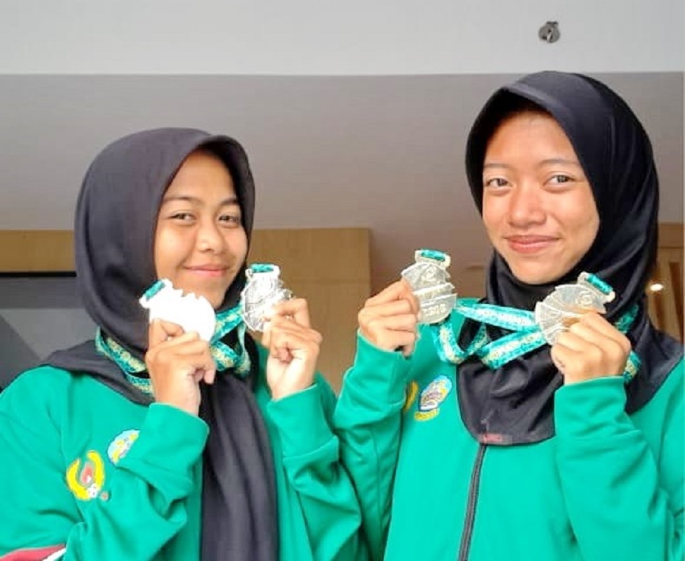 BERPRESTASI: Siswa SMAN 1 Kwanyar Amirah Tsabitah dan Francisca Ali Norwi menunjukkan medali porprov VIII yang diraih. (SMAN 1 KWANYAR UNTUK JPRM)