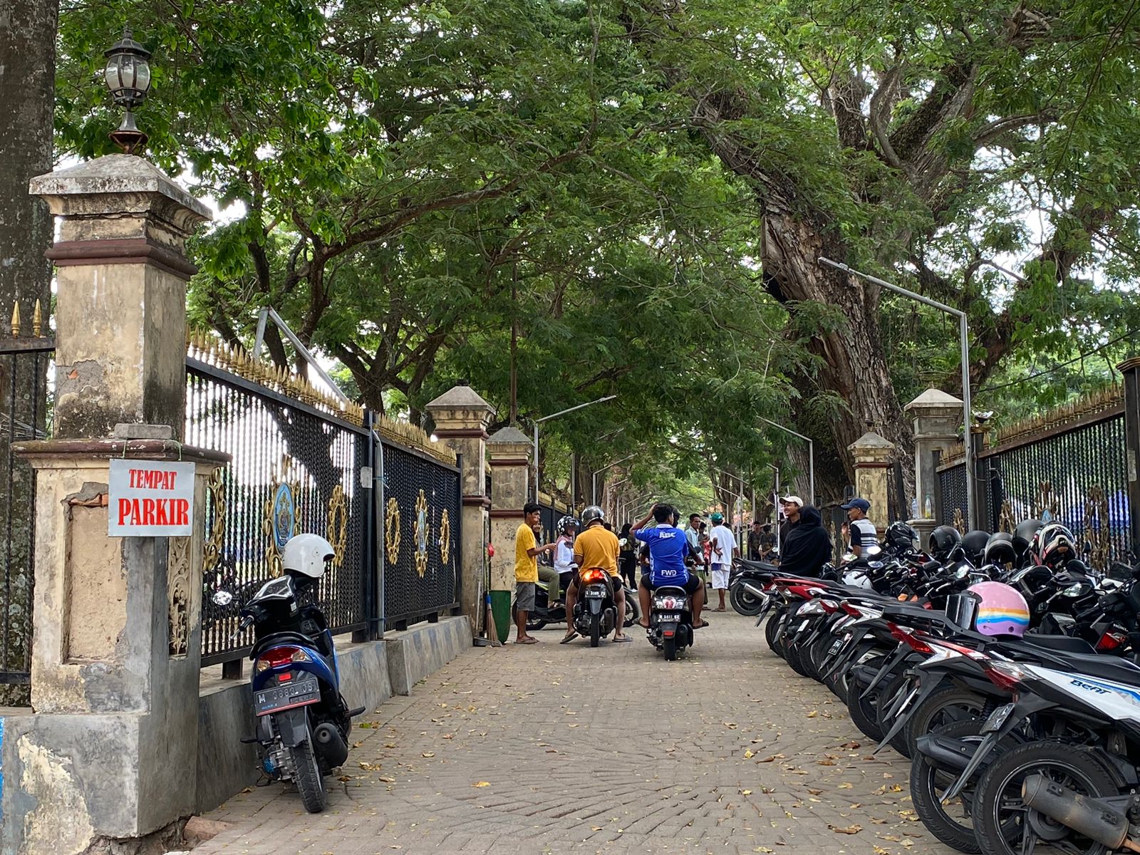 RETRIBUSI: Jukir (baju kuning) memberikan karcis masuk kepada pengendara motor di Taman Paseban Bangkalan, Minggu (12/11). (AYU LATIFAH/JPRM)