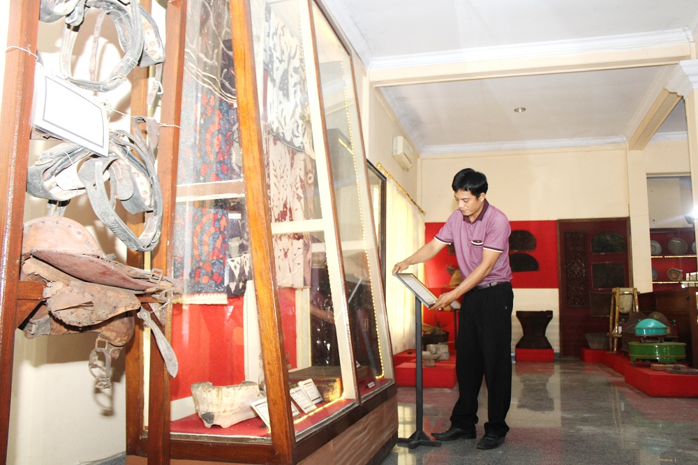BENDA BERSEJARAH: Pegawai Disbudpar Bangkalan menunjukkan koleksi Museum Cakraningrat, Rabu (23/8). (VIVIN AGUSTIN HARTONO/JPRM)
