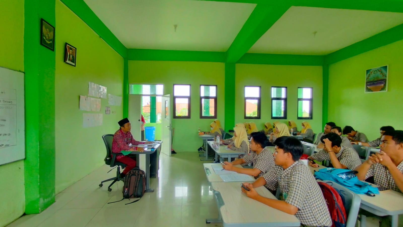 PAHLAWAN TANPA TANDA JASA: Seorang guru mengajar di kelas MAN 1 Bangkalan. (AYU LATIFAH/JPRM)