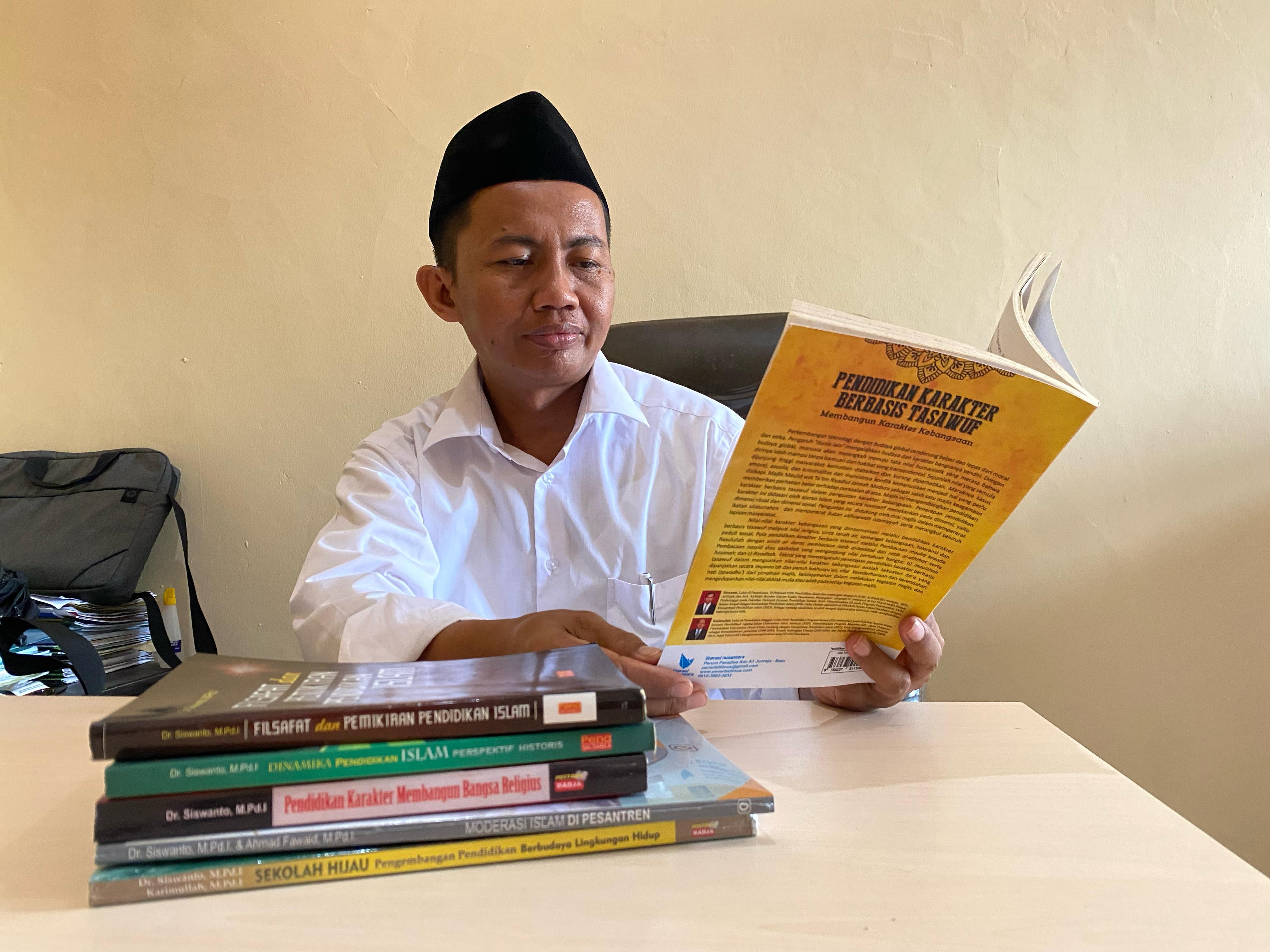 BERPRESTASI: Prof. Dr. Siswanto, M.Pd.I. membaca buku saat ditemui di ruang kerjanya Senin (13/11). (MOH. JUNAIDI/JPRM)