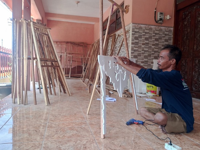 KREATIF: Suparman membuat karangan bunga pesanan pelanggan di rumahnya, Kelurahan&nbsp; Bugih, Kecamatan Kota Pamekasan, Sabtu (18/11). (UBAIDILLAHIR RA&rsquo;IE/JPRM)