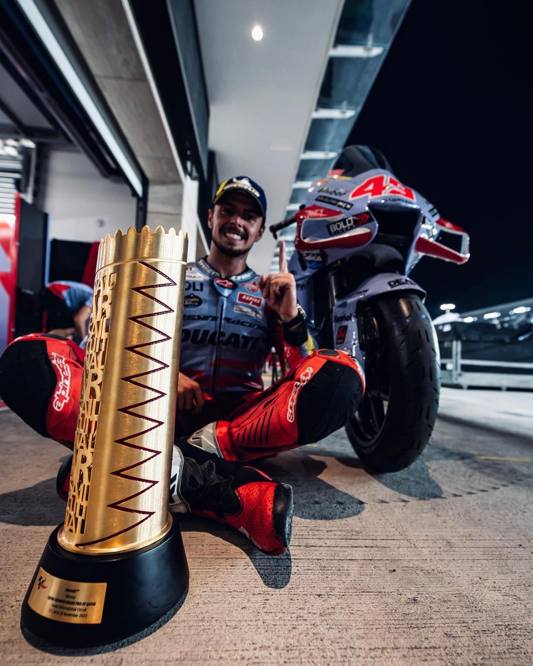 KEJUTAN: Fabio di Giannantonio berpose di belakang piala usai memenangkan seri balapan MotoGP Qatar 2023. (IG: @fabiodiggia49)