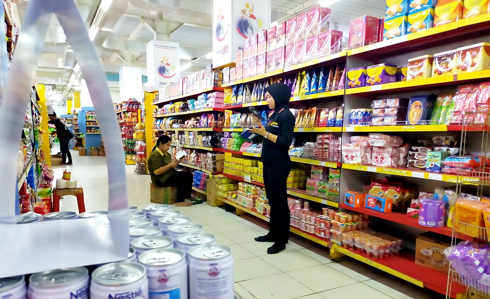 BEKERJA: Karyawan salah satu swalayan di Jalan Trunojoyo mendata produk yang ada di rak, Rabu (22/11). (VIVIN AGUSTIN HARTONO/JPRM)