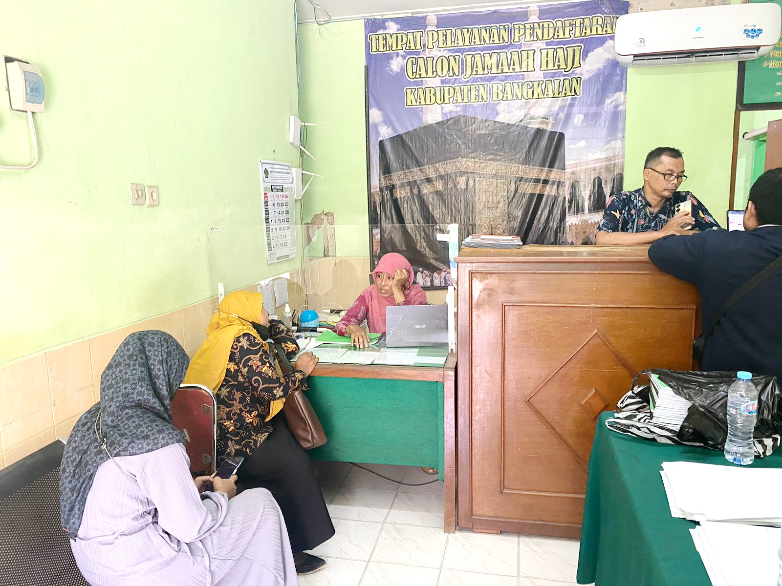 BERI PELAYANAN: Petugas sibuk melayani jemaah di Kantor Kemenag Bangkalan, Rabu (22/11). (AYU LATIFAH/JPRM)