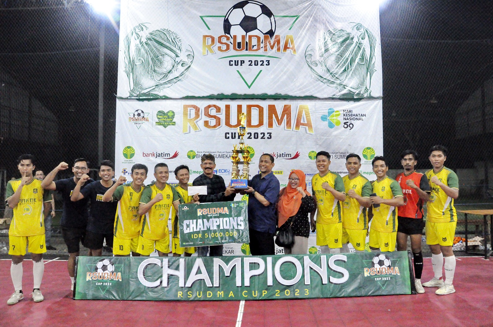 JUARA: Asisten 1 Bidang Pemerintahan dan Kesra Setkab Sumenep (pakai belangkon) menyerahkan hadiah juara 1 RSUDMA Cup 2023 kepada Tim Futsal Dinas Pendidikan Sumenep Minggu (26/11). (RSUDMA FOR JPRM)