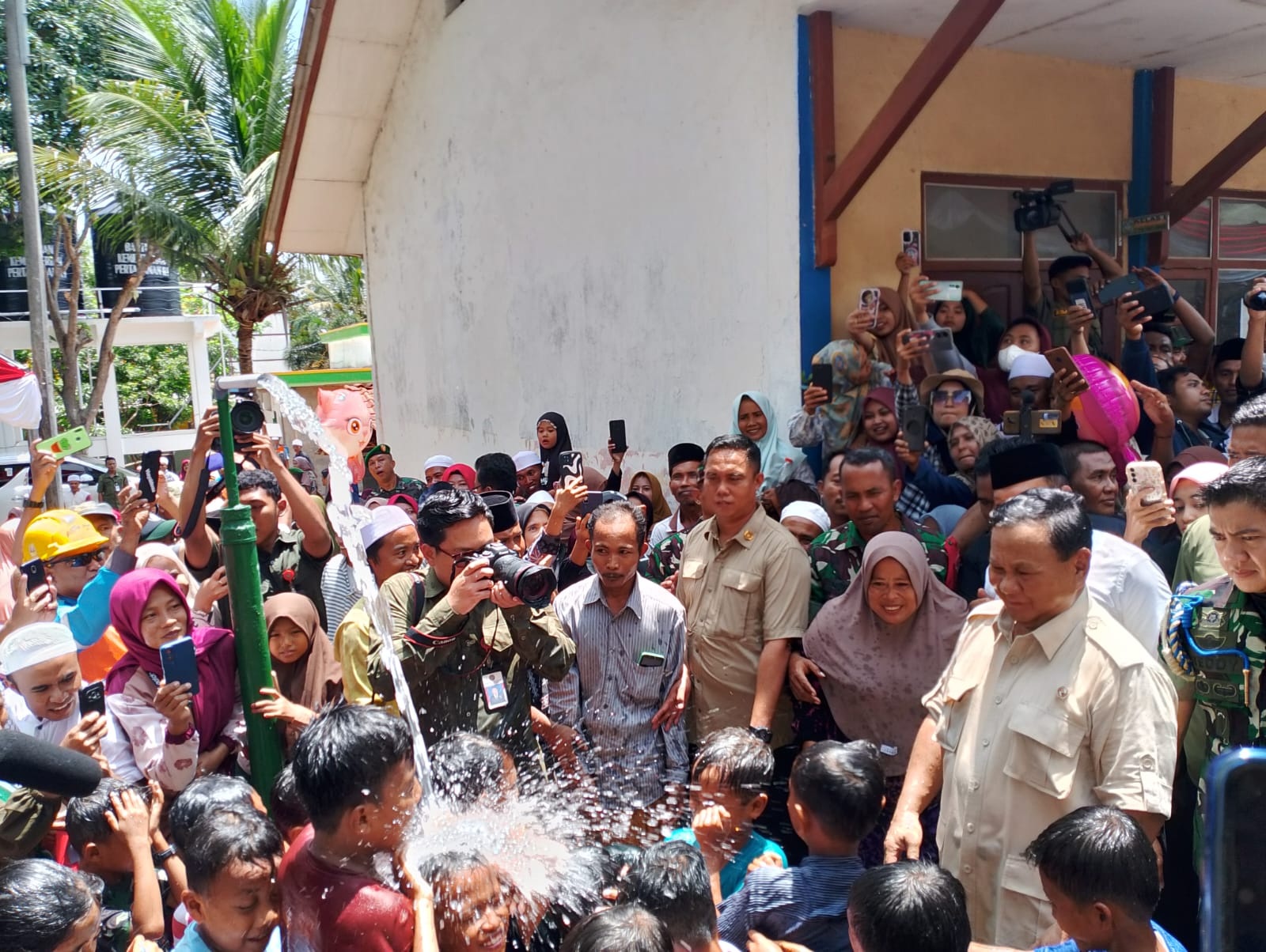 BASAH: Menteri Pertahanan Prabowo Subianto melihat keceriaan anak-anak yang mandi setelah meresmikan sumur bor dan pipanisasi di Desa Palengaan Daya, Kecamatan Palengaan, Pamekasan, Minggu (26/11).