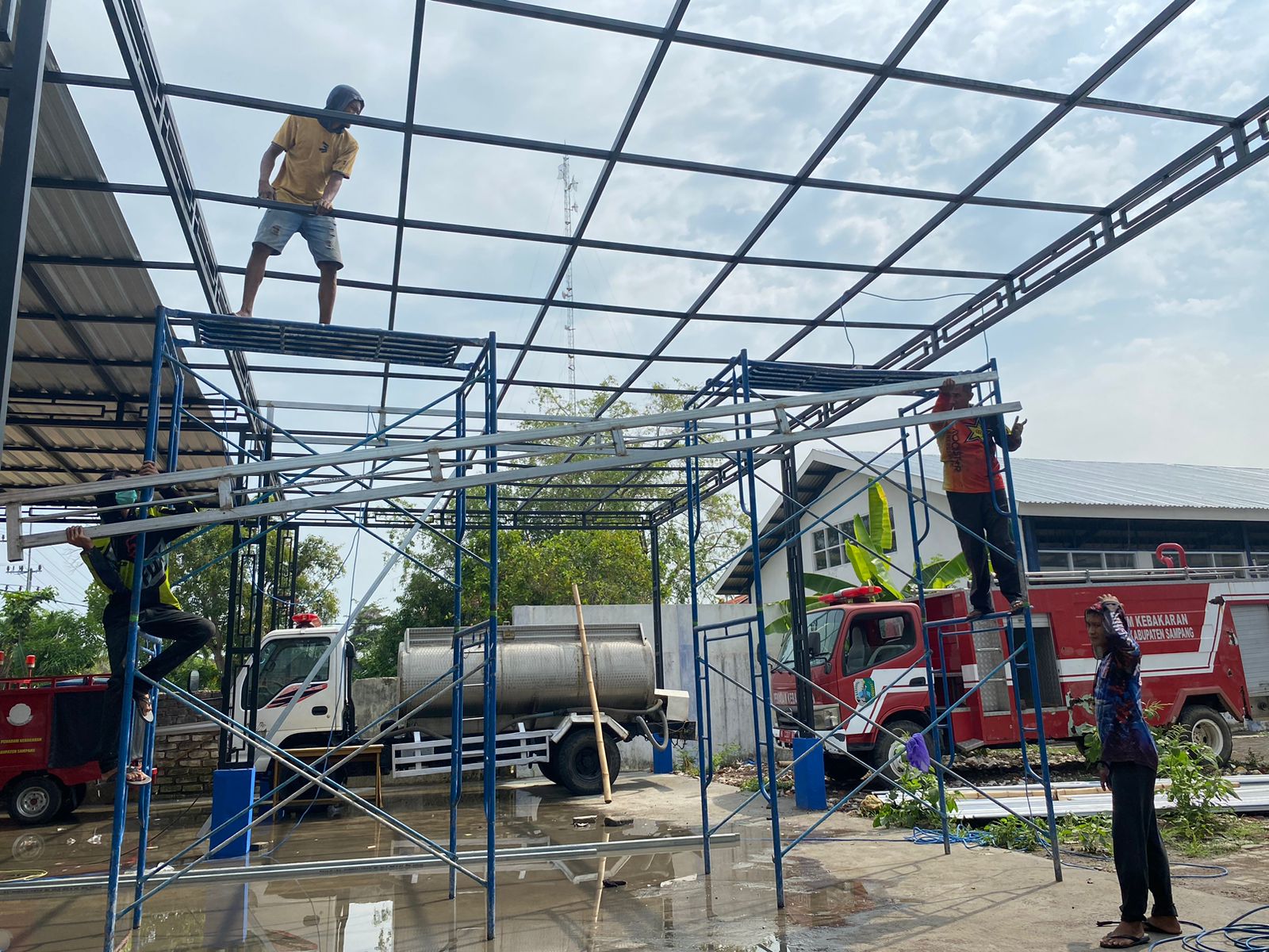 DIBONGKAR: Pekerja sedang memperbaiki tempat parkir damkar yang rusak Senin (27/11). (ANIS BILLAH/JPRM)