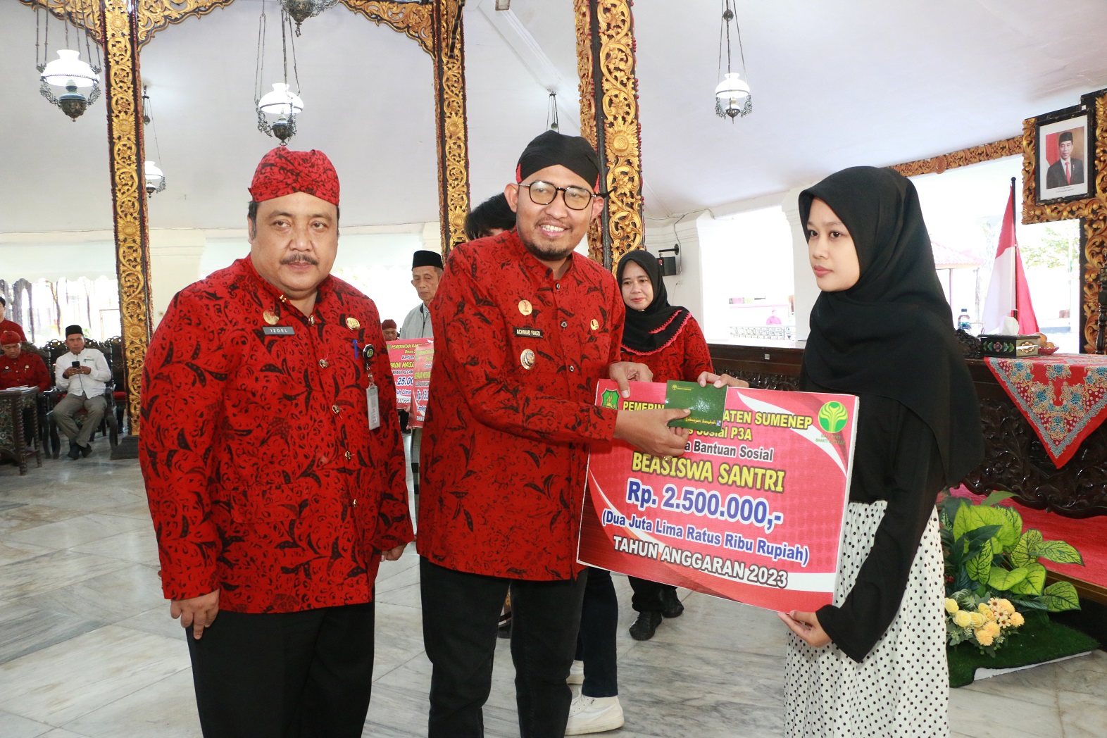 PEDULI: Bupati Achmad Fauzi Wongsojudo (tengah) didampingi Kepala Dinsos P3A Sumenep (kiri) menyerahkan bansos beasiswa di Pendopo Agung Keraton Sumenep pada Jumat (4/8). (PROKOPIM SUMENEP UNTUK JPRM)