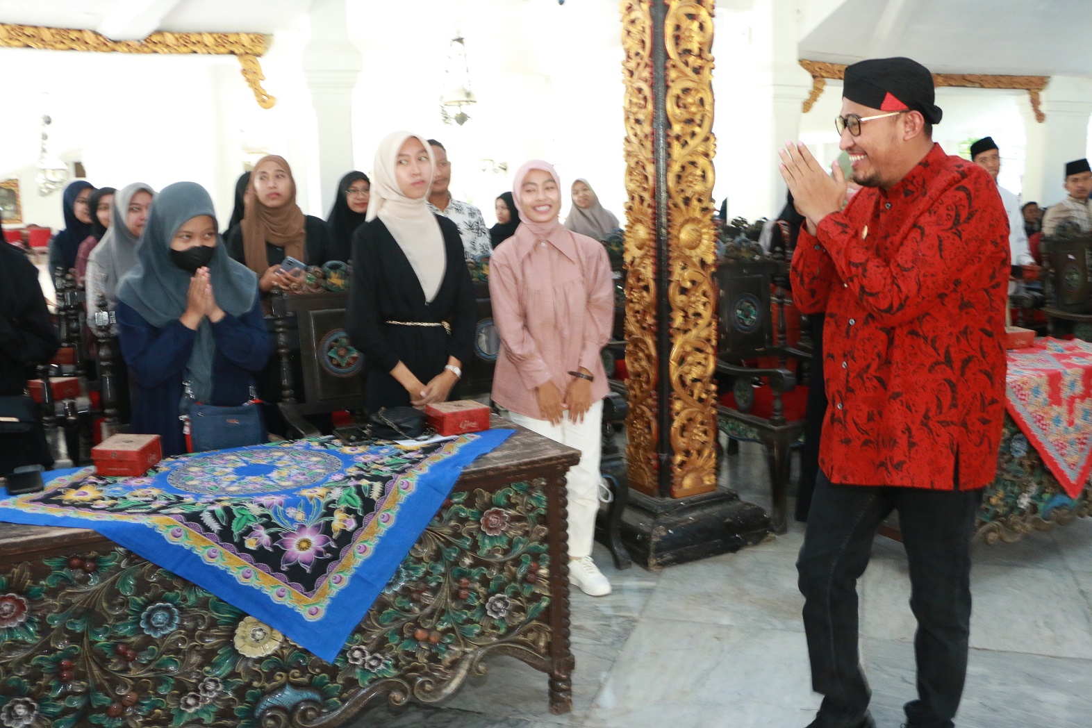 MERAKYAT: Bupati Sumenep Achmad Fauzi Wongsojudo (pakai belangkon) menyapa para penerima bansos beasiswa di Pendopo Agung Keraton Sumenep, Jumat (4/8). (PROKOPIM SUMENEP UNTUK JPRM)