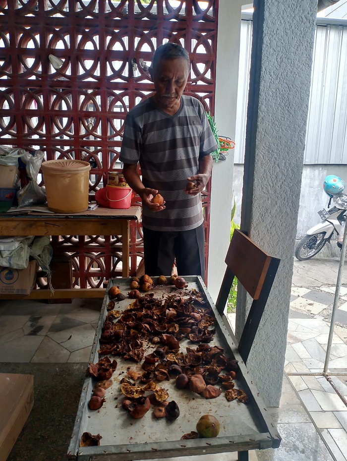 RUTIN: Muzaini mengecek kulit delima yang dikeringkan di rumahnya, Kelurahan Bugih, Kecamatan Kota Pamekasan, Sabtu (25/11). (UBAIDILLAHIR RA&rsquo;IE/JPRM)