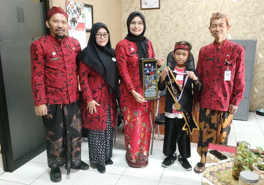 PRESTISIUS: Jaka Cahraka, murid SMPN 1 Dasuk, berfoto dengan pejabat di kantor dinas pendidikan setelah tiba dari Jepang, Jumat (1/12). ((YULIANTI UNTUK JPRM))