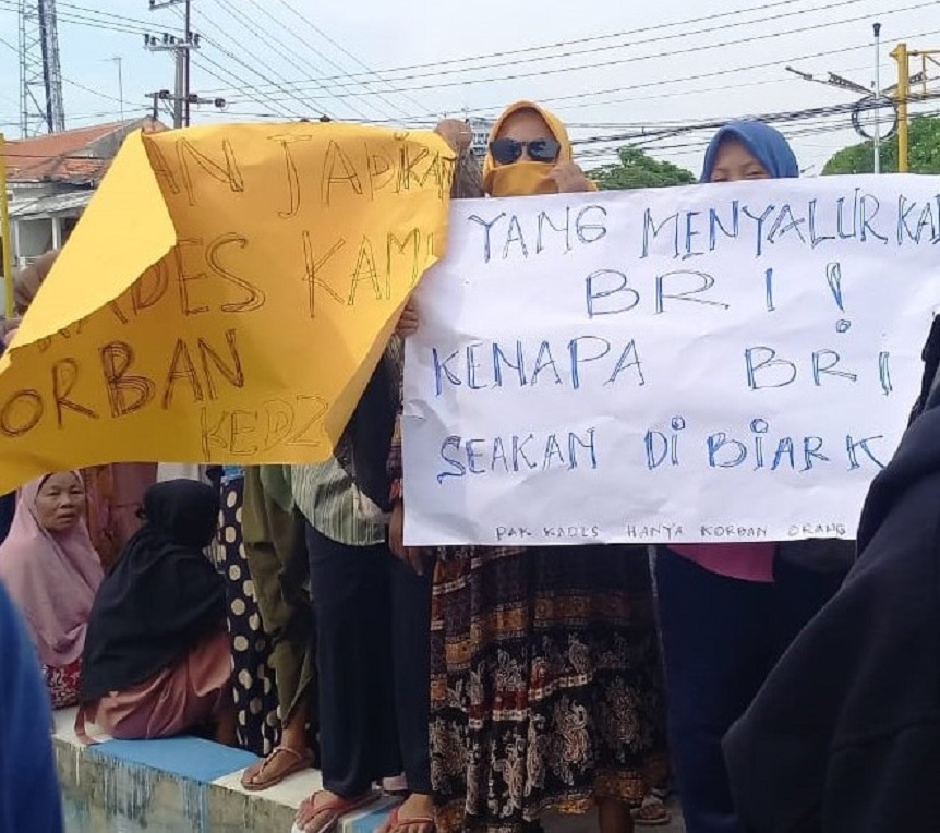 BERI SUARA: Dukungan warga Desa Gunung Rancak terhadap kades mereka disalurkan melalui tulisan di beberapa poster. (MOH. IQBAL AFGANI/JPRM)