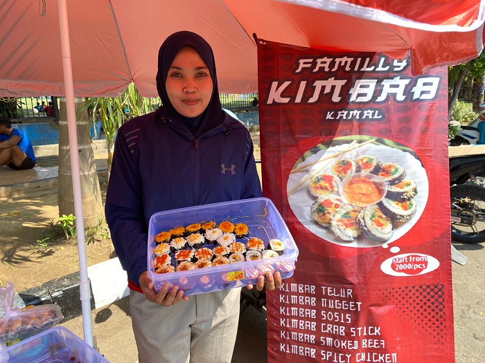 TEKUN: Nurul Komaria menunjukkan dagangan kimbab buatannya Minggu (19/11). (AYU LATIFAH/JPRM)