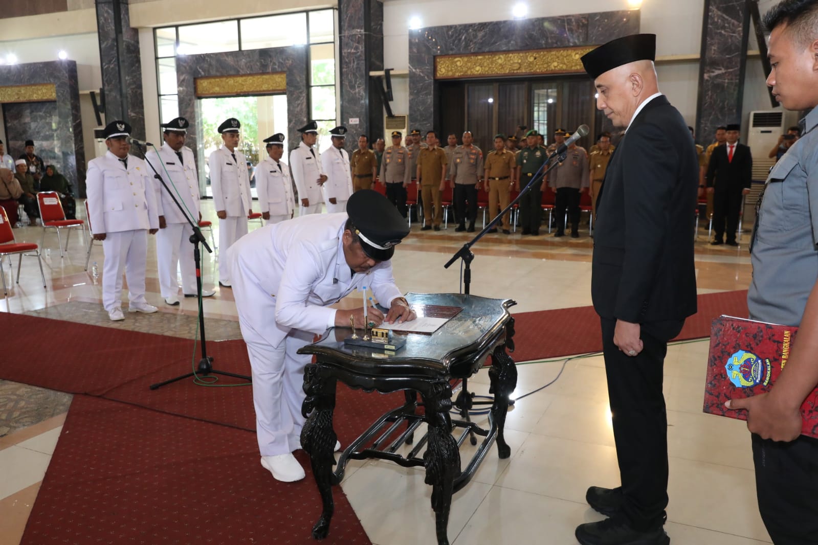 FORMAL: Pj Bupati Bangkalan Arief M. Edie menyaksikan penandatangan berita acara pelantikan Kades di Gedung Serbaguna Rato Ebu, Selasa (5/12). (PROKOPIM UNTUK JPRM)