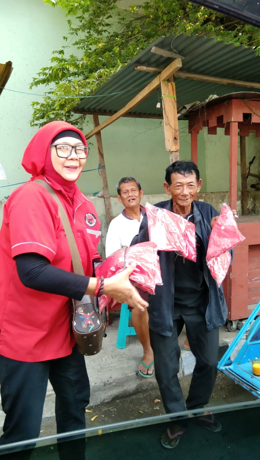 DITERIMA MASYARAKAT: Kader DPC PDI Perjuangan Bangkalan menyerahkan kaus kepada tukang becak. (PDI PERJUANGAN UNTUK JPRM)