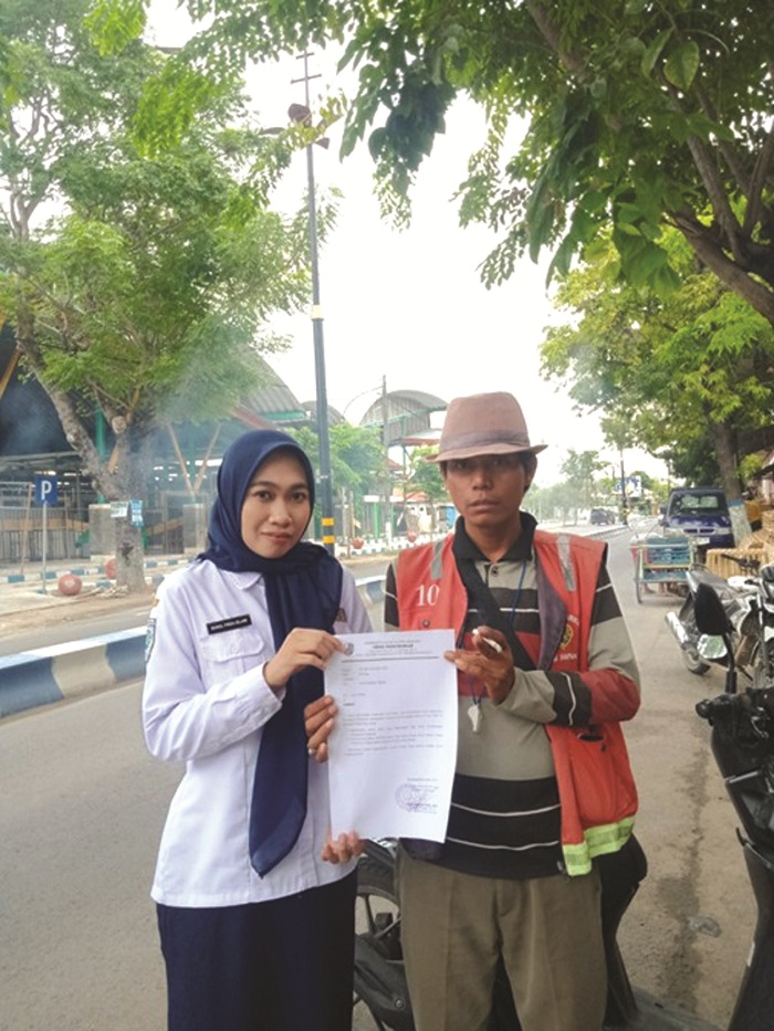 AKTIF: Petugas Dishub Sampang melakukan monitoring pengawasan dan menyebarkan surat edaran kepada juru parkir di Jalan Syamsul Arifin. (DINAS PERHUBUNGAN UNTUK JPRM)