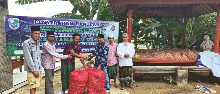 SIMBOLIS: Pemerintah Desa Tamberu Daya, Sokobanah, Sampang, menyerahkan bantuan bibit bawang merah kepada kelompok tani Sabtu (8/7). (ANSORI UNTUK JPRM)